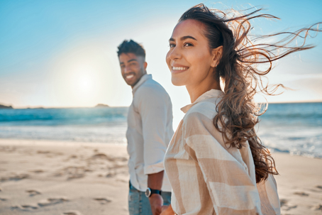 happy couple walking along the beach